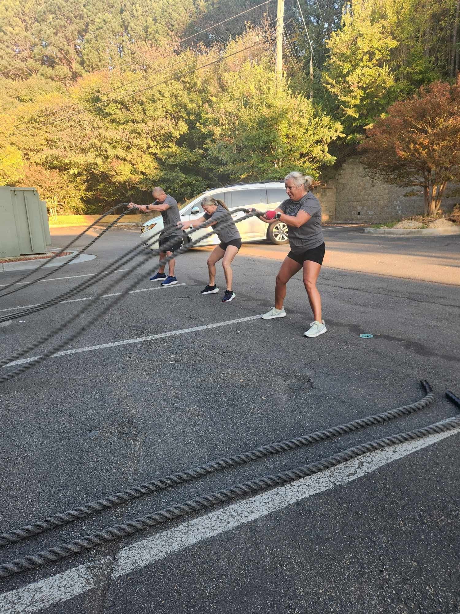 Participants working the battle ropes outside during the event